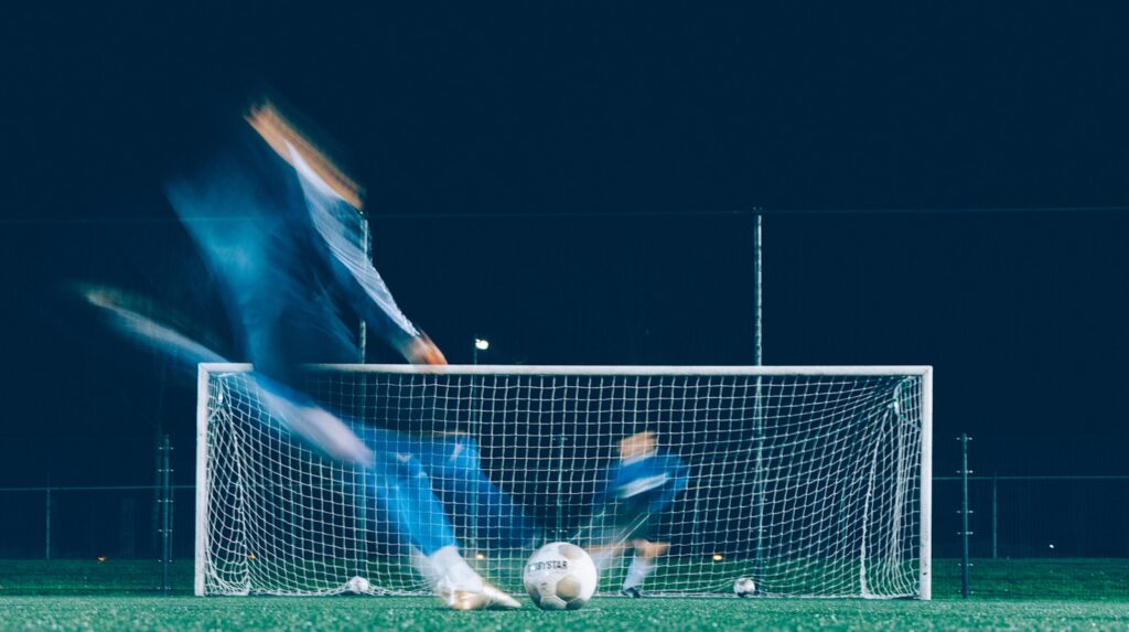 Verdediger onderschept de bal in een duel op een voetbalveld