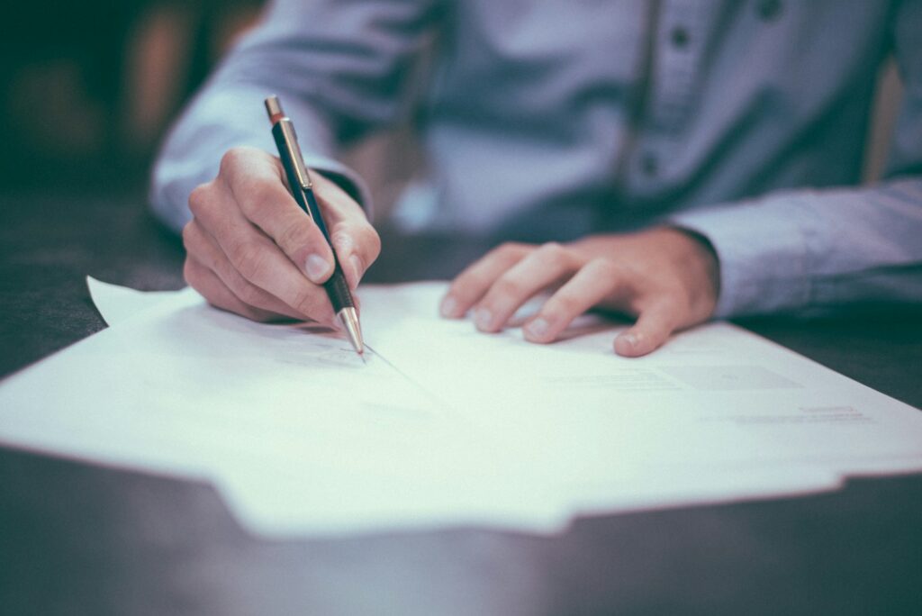 Vulpen op een ondertekend contract op een houten tafel