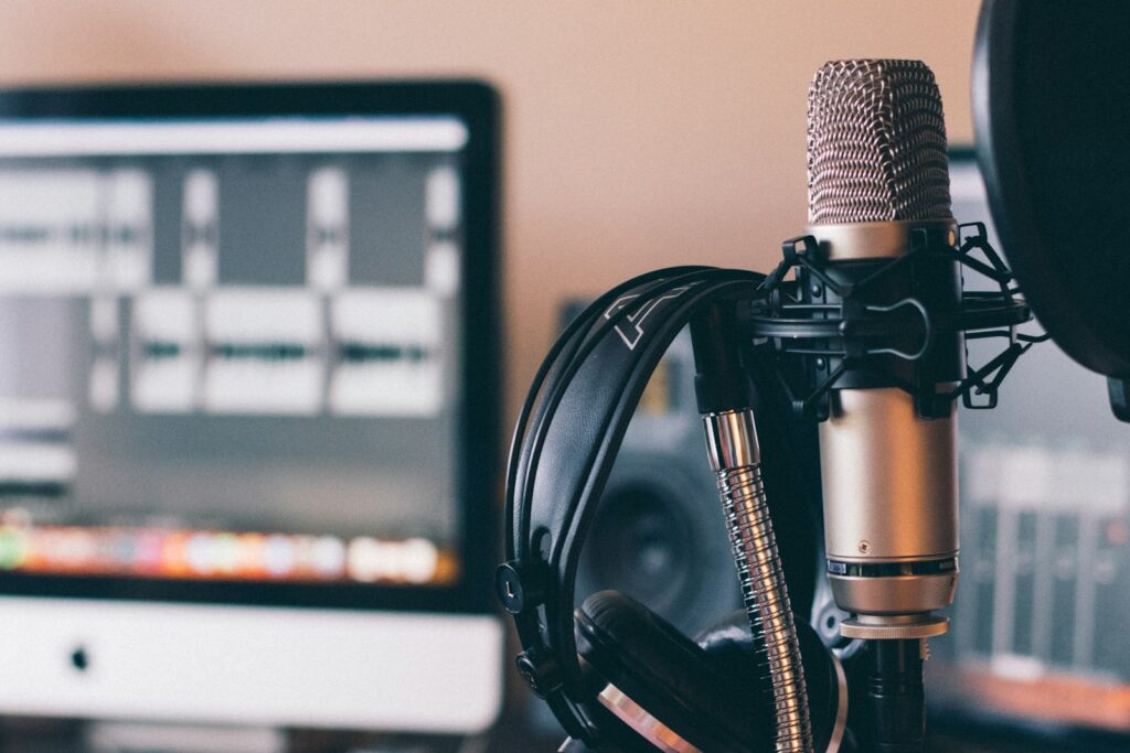 Podcastmicrofoon en koptelefoon op een houten tafel