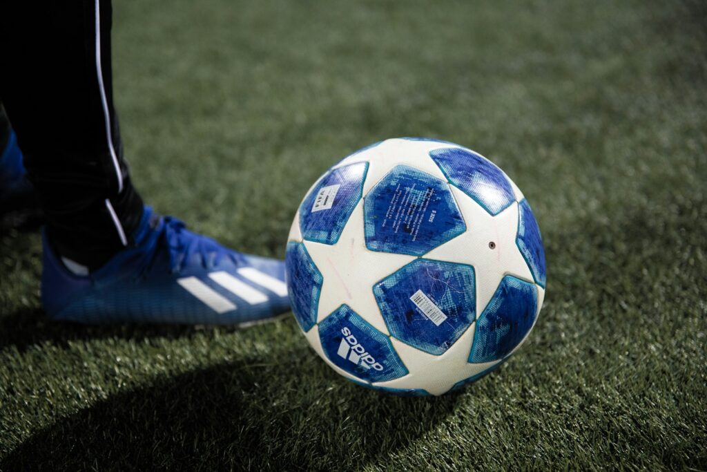 Voetbalschoenen op het gras van een stadion, van dichtbij
