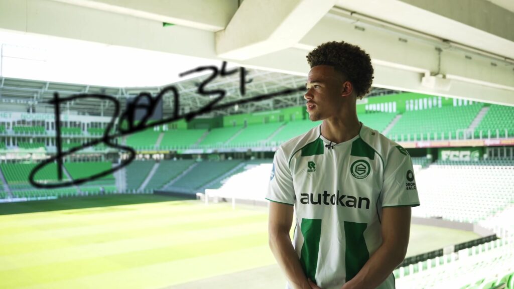 Ryan Metu in het thuisshirt van FC Groningen op de tribune van Euroborg