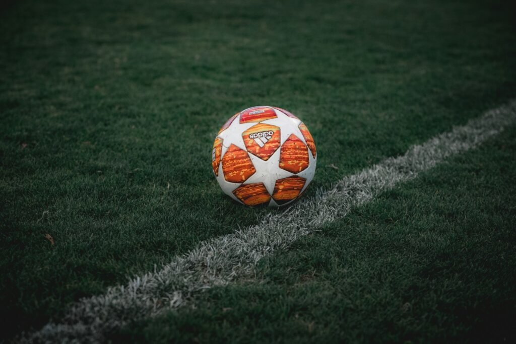Voetballer in een oranje shirt tijdens een training op het veld